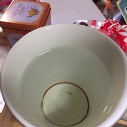 汚れたマグカップに水を入れる